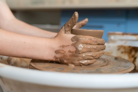 person is making a pot on a potter's wheel photo