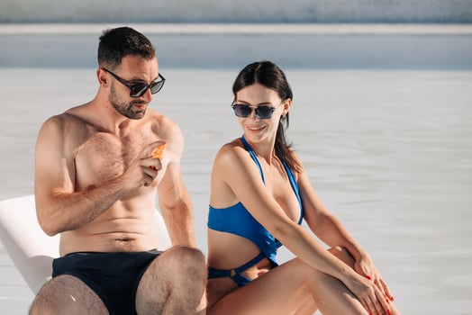 Couple applying sunscreen at the beach photo
