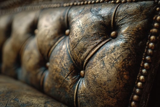 Close up of luxurious gold leather upholstery featuring a weathered patina and elegant tufting design in a vintage style photo
