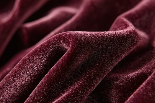 Deep burgundy velvet fabric showcasing texture and elegance in a macro shot revealing intricate details photo
