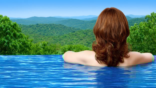 A woman in a pool looking out over the mountains photo