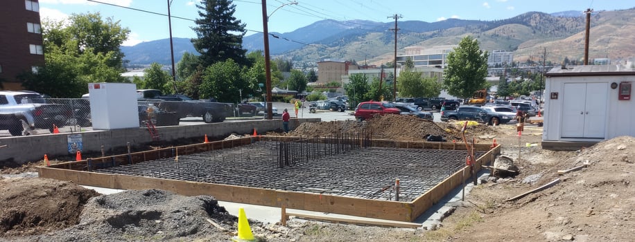 A concrete foundation is being poured in a parking lot photo