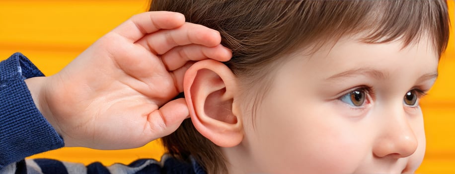 A child is holding his ear to the side photo