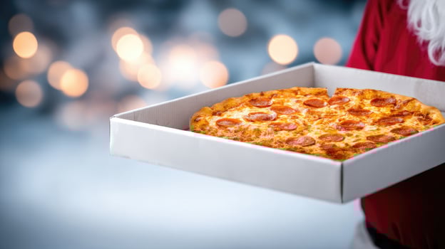 A santa claus holding a pizza in a box photo
