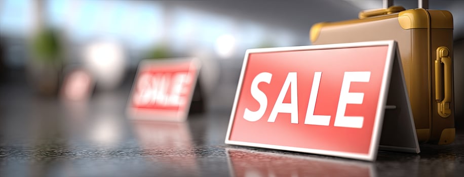 A suitcase is sitting next to a sale sign photo