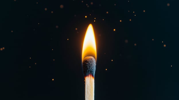 A matchstick lit on fire with sparks flying photo