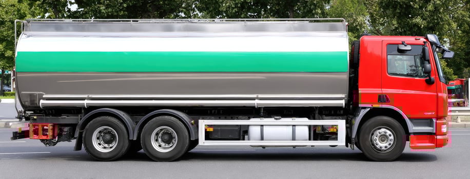 A large tanker truck with a green and white paint job photo