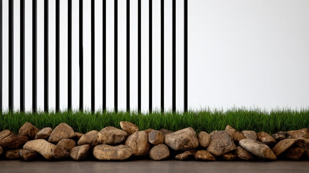 A wall with grass and rocks in front of a black and white striped wall photo