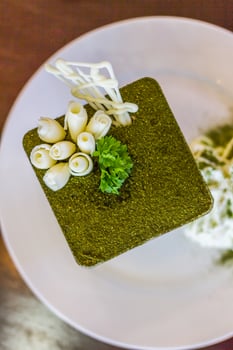 A square of green food on a white plate photo