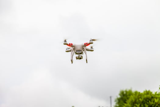 A white and red drone flying in the air photo