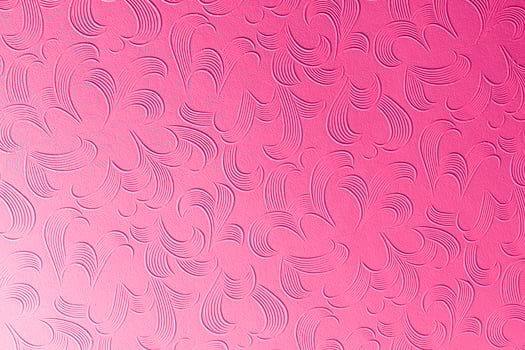 A pink background with a pattern of swirls photo