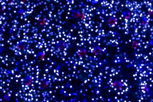 A blue and red lighted background with many small lights photo
