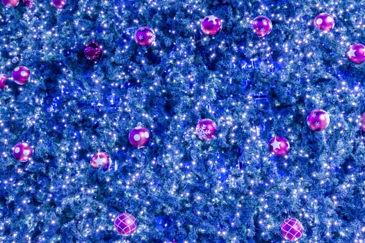 A blue christmas tree with pink balls and lights photo