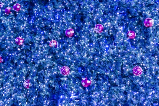 A blue christmas tree with pink and purple balls photo