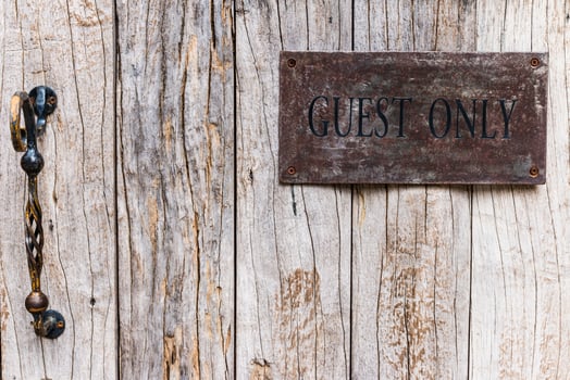 A sign on a wooden door that says guest only photo