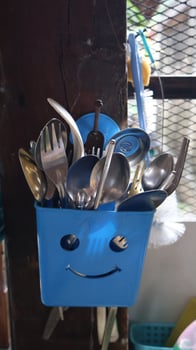 A plastic cutlery holder hangs in the kitchen photo