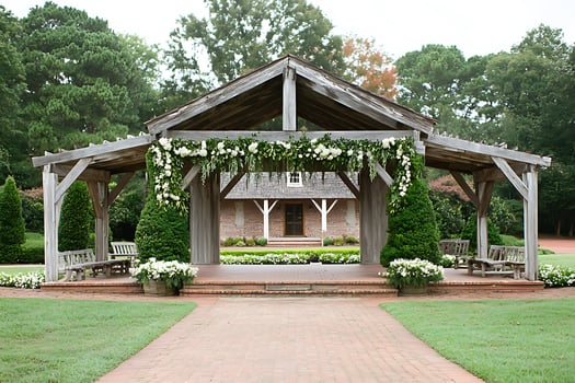 Rustic Wooden Pergola with Floral Decor and Brick Pathway. A charming outdoor wedding ceremony or event space. photo