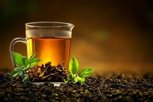 A Glass Pitcher of Golden Tea with Fresh Leaves and Tea Leaves. A vibrant image perfect for tea brands, health and wellness, or food and beverage businesses. photo