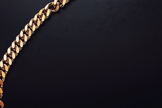 Gold Chain on Black Background Luxury Jewelry Image. A high-resolution image of a gleaming gold chain diagonally positioned against a dark background, perfect for design projects. photo