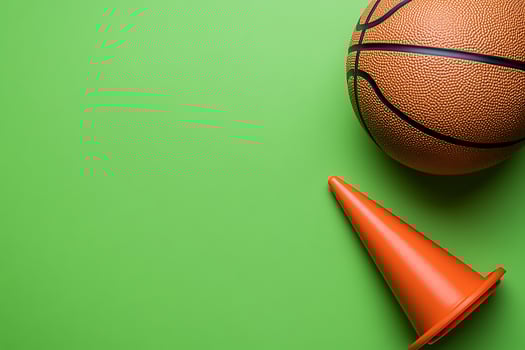 Basketball and Traffic Cone on Green Background Sport and Safety Concept. photo