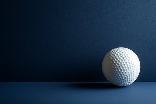 Close-up of a Single Golf Ball Against a Deep Blue Background. A striking image perfect for sports-related projects and design. photo