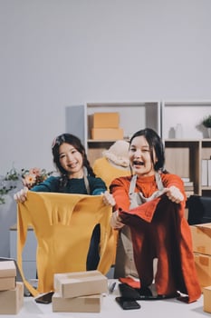 Two women holding up a shirt and a box photo