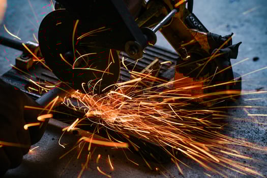 Cutting a steel plate with electric cutting wheel at a factory photo