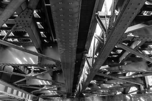 Beautiful interplay of light and shadows under urban steel architecture showcasing intricate designs in a busy city photo