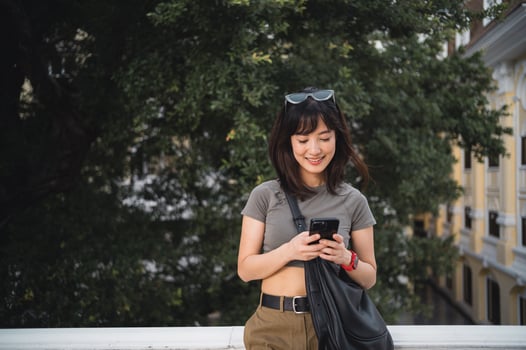 Smiling young southeast asian woman teenager blogger and world travel explorer Asia. Searching smartphone map for local cultural guide tourism concept experience Bangkok Thailand Chao Phraya River photo