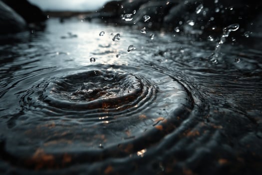 Water drops falling from a circular object into a body of water photo