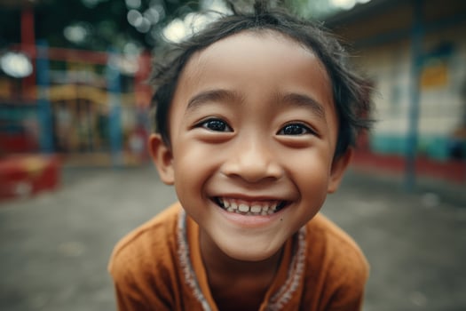 A young asian child smiles for the camera photo