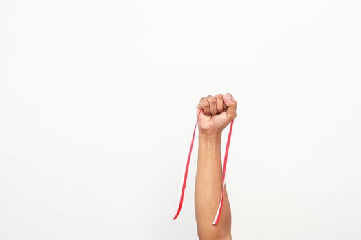 Isolated fist holding a red and white ribbon, symbolising strength and Indonesian Independence Day photo