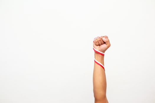 A raised fist wrapped in a red and white ribbon symbolizing Indonesian independence day spirit photo