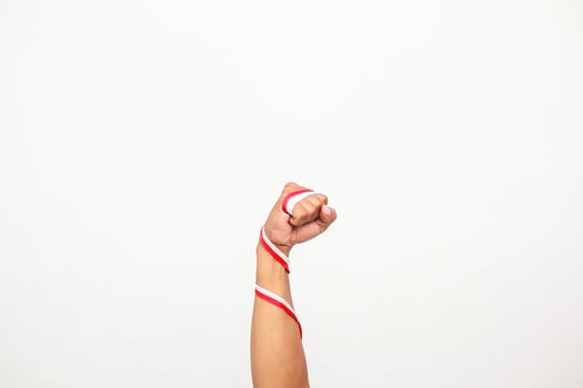 A fist with a red and white ribbon wrapped around the arm, symbolizing strength and patriotism photo