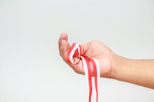 Hand holding Indonesian flag ribbon celebrating Independence Day, symbolizing freedom and patriotism photo