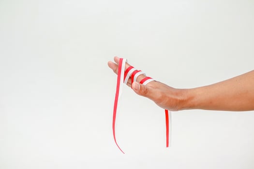 Hand holding the red and white ribbon, a symbol of Indonesian Independence Day concept photo
