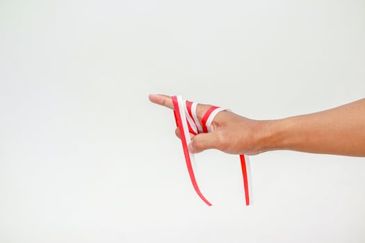 Hand with Red and White Ribbon Symbolic of Indonesian Independence Day Celebration photo