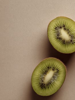 Kiwi Halves Floating on a Neutral Canvas Background Evoke a Sense of Freshness and Minimalism in This Simple yet Striking Composition photo
