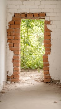 Ancient brick doorway in a decaying wall, revealing vibrant green nature beyond. A captivating scene of architectural ruin and natural reclamation. photo