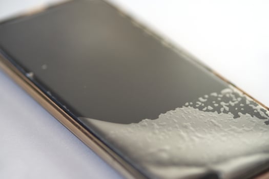 Close-up of smartphone screen crack repair process with protective film. photo