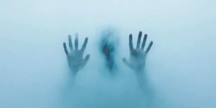 Mysterious silhouette behind foggy glass creating an eerie and haunting atmosphere in a dimly lit space at twilight photo