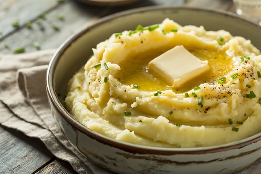 Delicious creamy mashed potatoes with melted butter and fresh chives in a rustic bowl photo