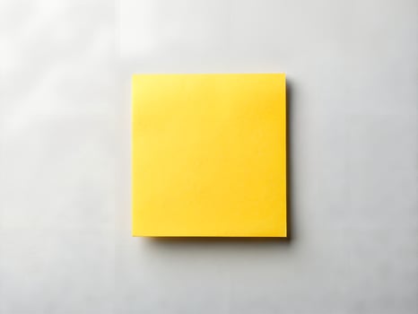 Bright Yellow Sticky Note on a Light Grey Textured Background photo