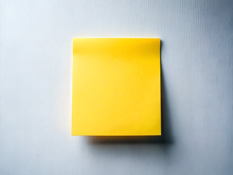 a yellow sticky note on a white surface photo