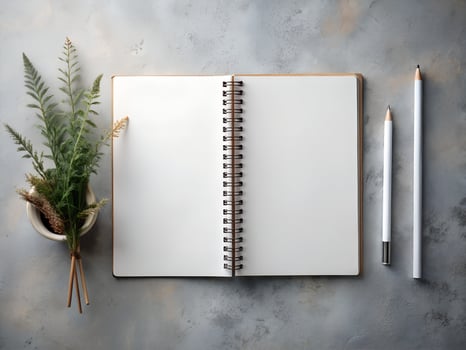 Blank Notebook with Pencils and Greenery on Grey Desk photo