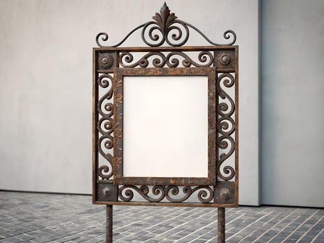 Blank Ornate Wrought Iron Sign Frame Against a Light Wall photo