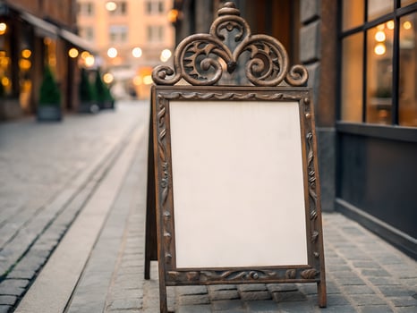 Blank Ornate Signboard on Cobblestone Street in European City photo