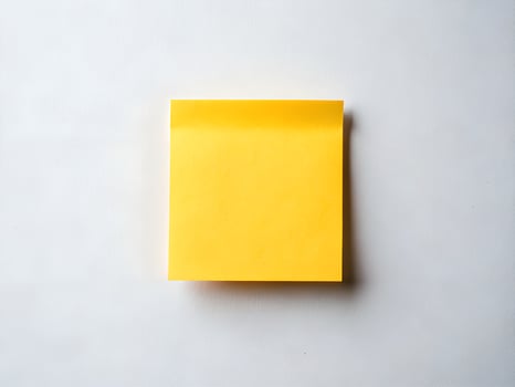 Bright Yellow Sticky Note on White Textured Background photo