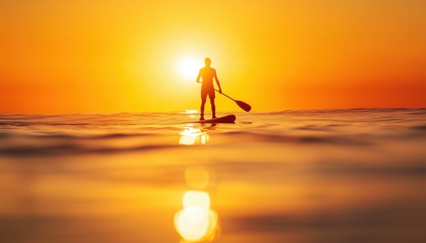 Silhouette Of Stand Up Paddle Boarder Enjoying The Sun On A Warm, Tranquil Sea With A Paddle In Hand. photo