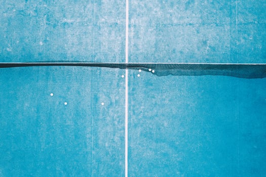 downward aerial drone footage on a blue paddle tennis court, racket sports courts concept photo